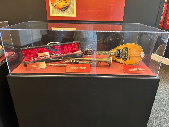 A collection of different Gretsch instruments inside a showcase.