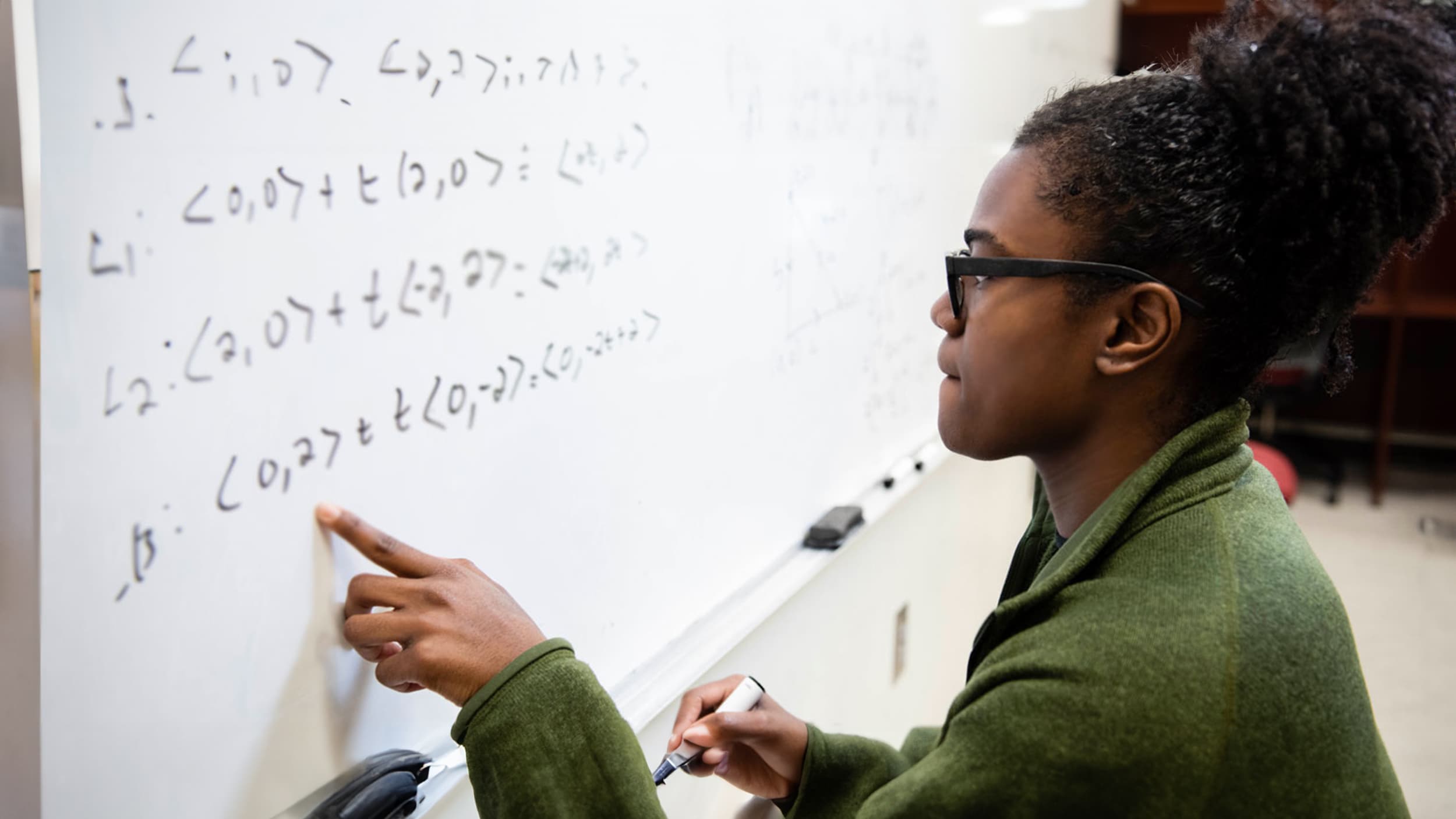 Georgia Souther student solves a mathematical equation on while board with confidence.