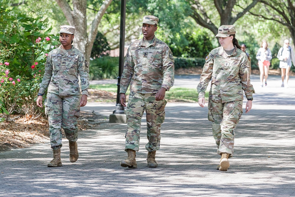 Three U.S. Army soldiers walk down a path at Georgia Southern University.