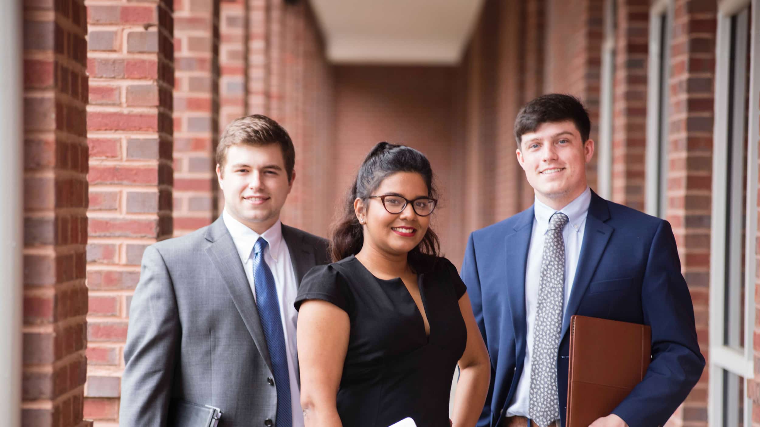 Three Georgia Southern students in business attire prepare to be young professionals in economics.