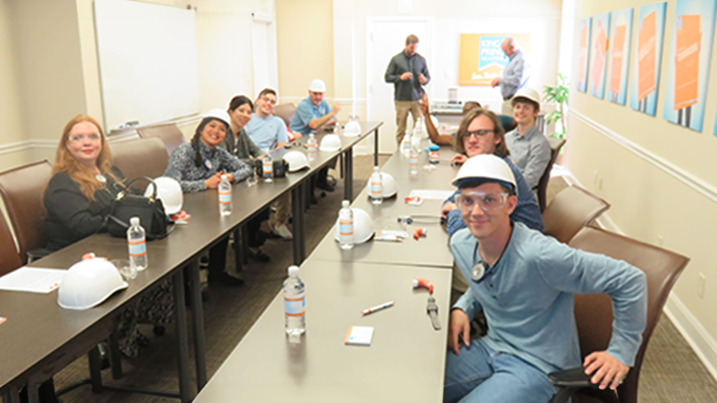A group of students wearing construction safety great prepare in boardroom to go on a project site for construction management.