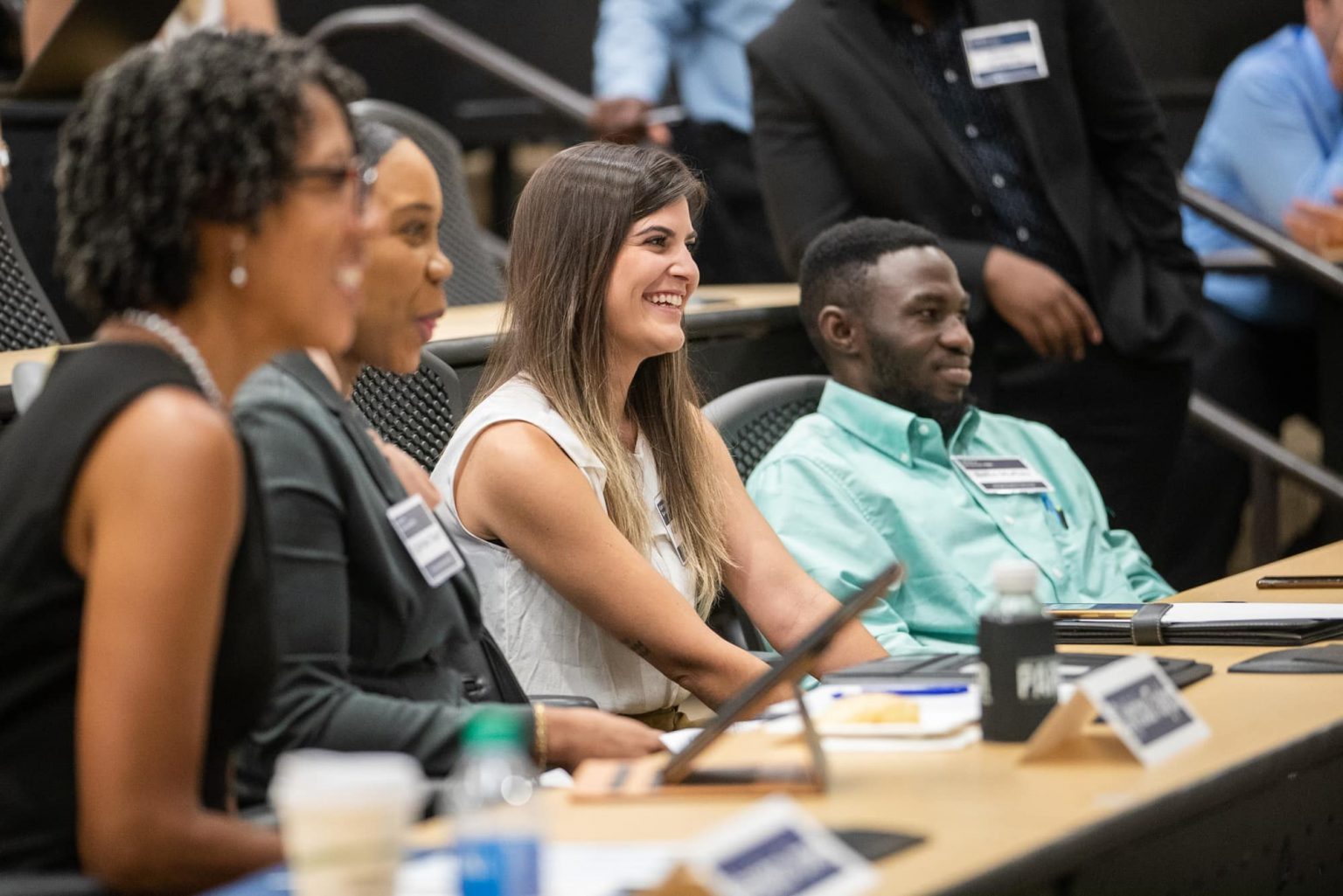 Parker College of Business accountancy students engaged in a classroom discussion, smiling and taking notes.