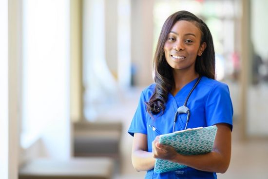 A Georgia Southern minority graduate in nurse scrubs enjoying a successful career as a nurse.