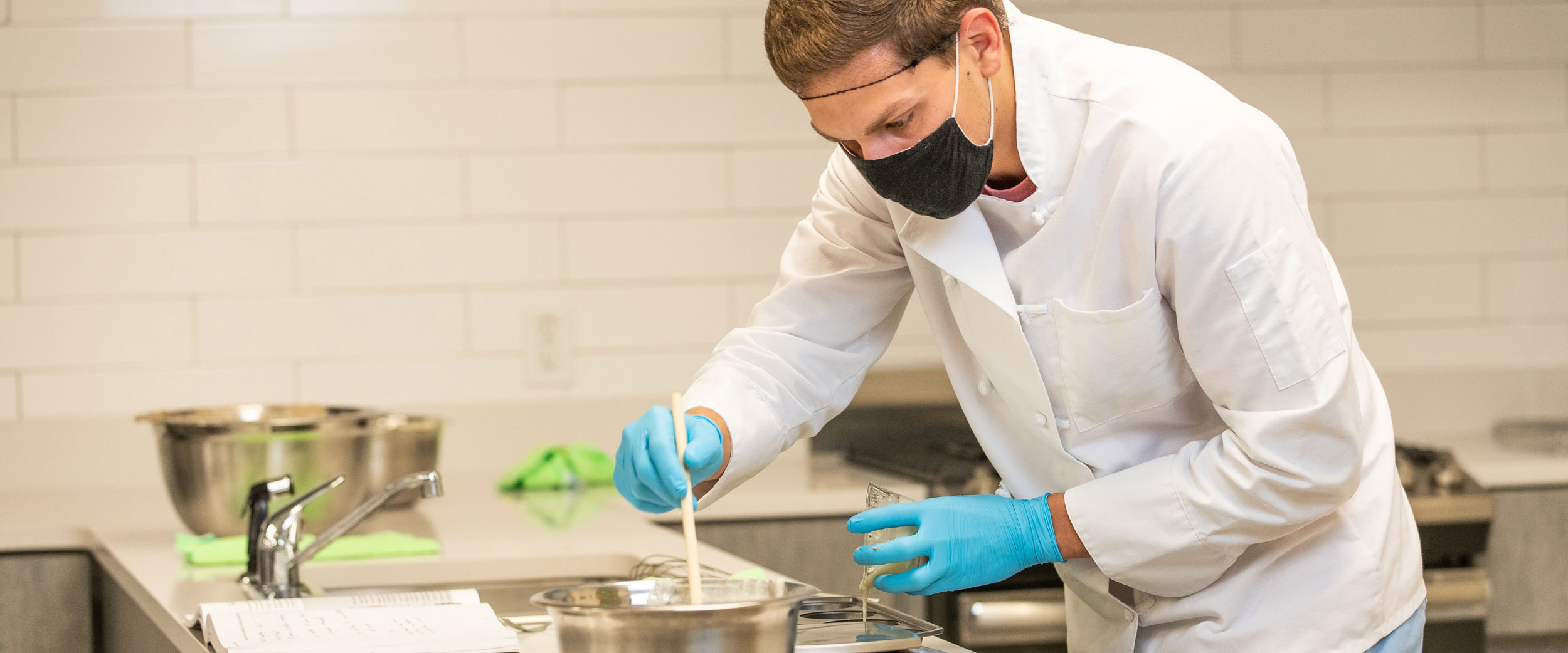 A B.S. in Nutrition and Food Science student mixes multiple food samples in a kitchen and home economics laboratory at Georgia Southern