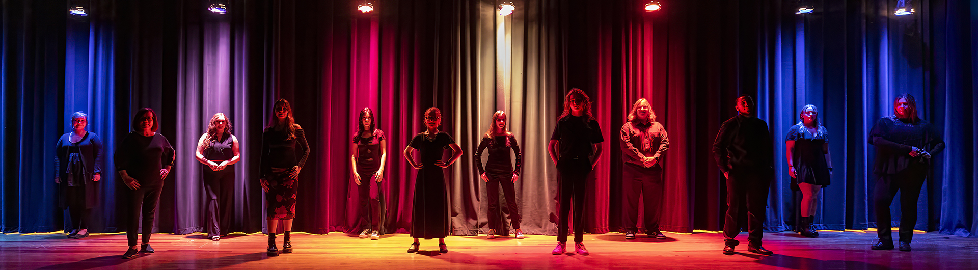 Georgia Southern College of Arts and Humanities students stand in a staggered row for a stage production involving colorful lights