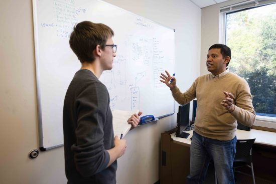 Georgia Southern professor teaching a student one on one with a whiteboard