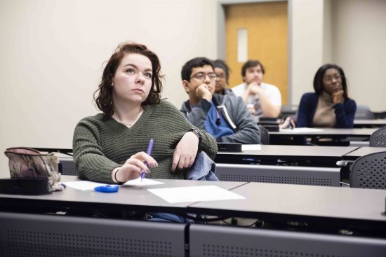 Georgia Southern female student sitting in classroom with diverse group of students sitting behind her