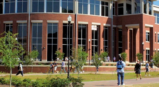 Students walking outside the Information Technology building at Georgia Southern, with tall windows and red brick exterior.