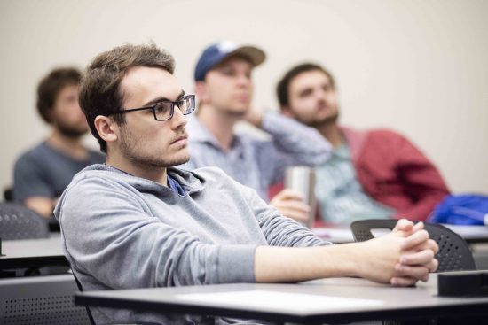 Georgia Southern male student sitting in classroom learning with other male students