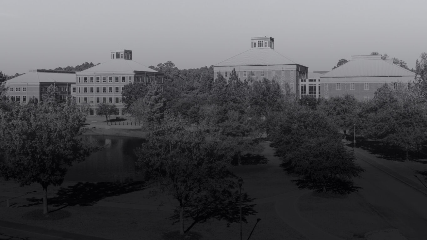 Black and white photo of Georgia Southern campus buildings with lake.