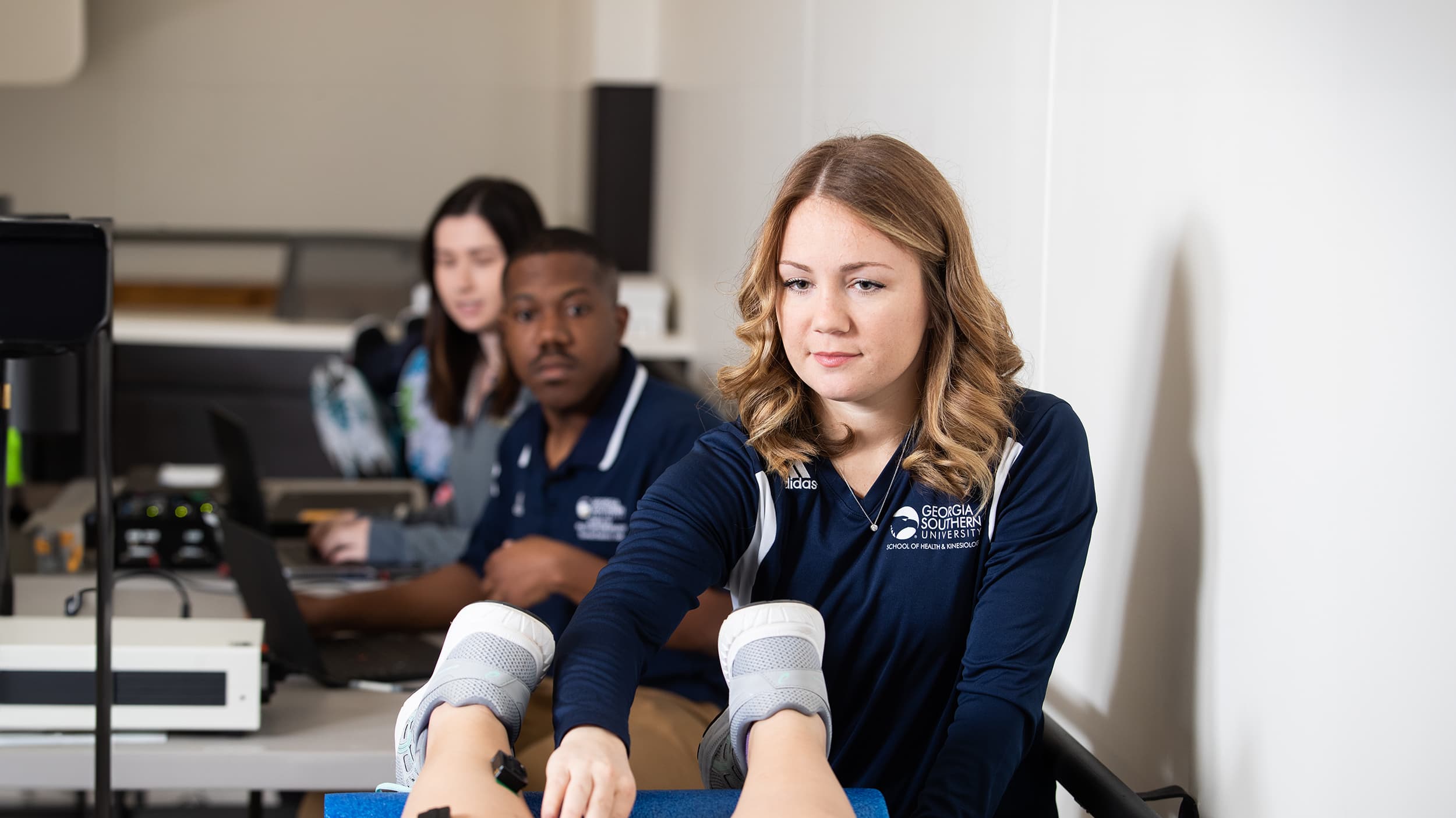 Georgia Southern students watch along as a health science major preforms a physical therapy exam.