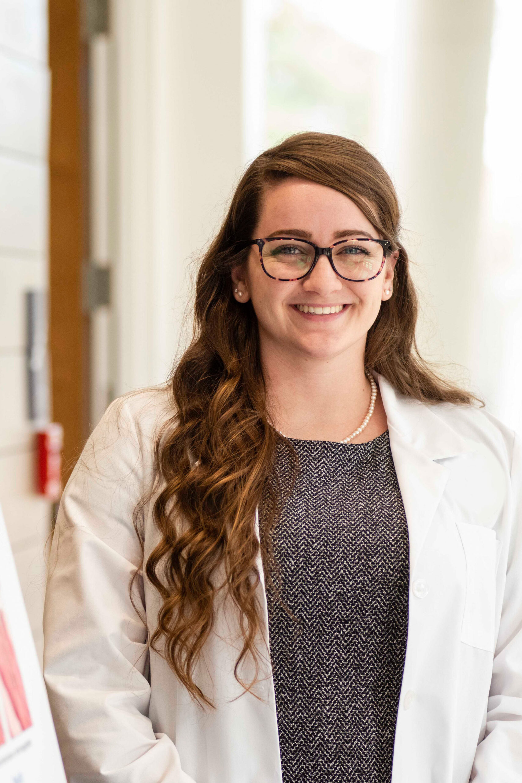 Graduate student poses for beginning of career in business attire with confidence and skills for a successful future.