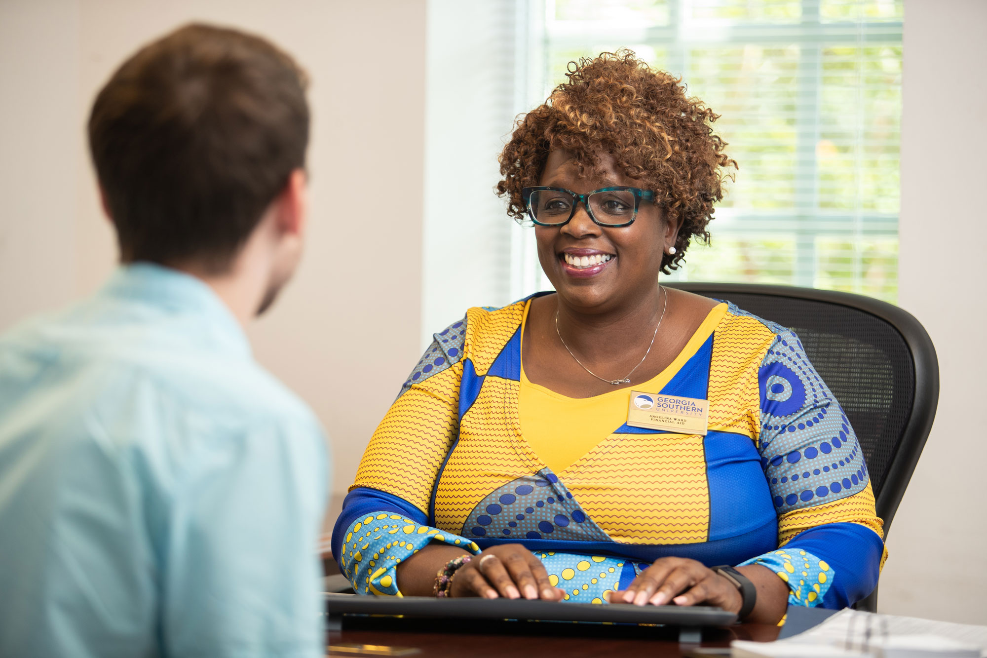 Georiga Southern admissions faculty smiles warmly as she processes information on a newly accepted transfer student.