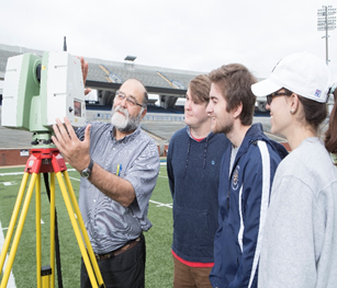 A professor teaching three students civil engineering on the Georgia Southern football field