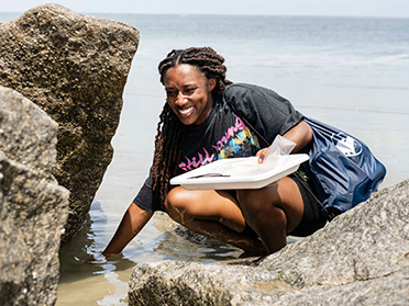 A student from Georgia Southern's Department of Biology gathers samples from a coastal area