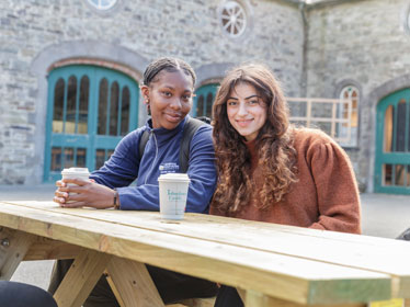 Two Georgia Southern Honors Global Scholars enjoy coffee outdoors during a study abroad trip