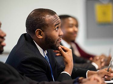 Wearing suits, graduate students from Georgia Southern's Parker College of Business listen during a lecture.