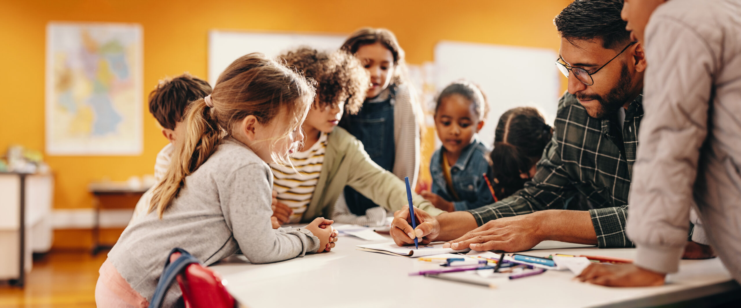 Georgia Southern student-teacher at a table with children, art instructor giving a demo to class.