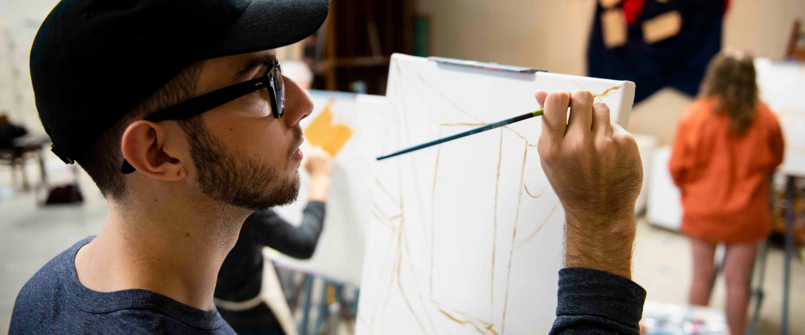georgia southern student at an easel painting, in art class