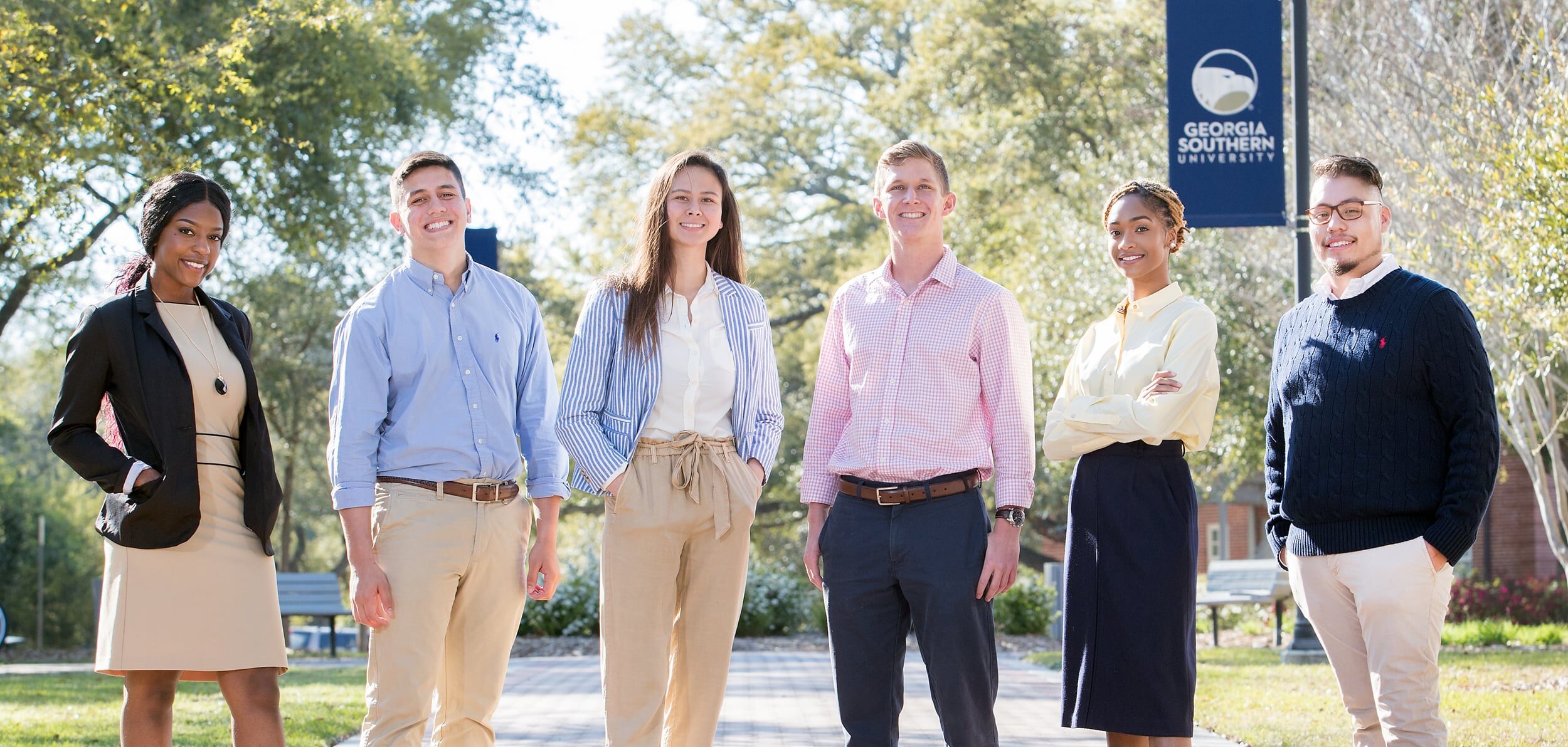 A group of young professionals stand on the Georgia Southern campus as they complete the Political Science program.