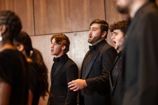 A group of Georgia Southern students sing A cappella during a choral performance in a concert hall.