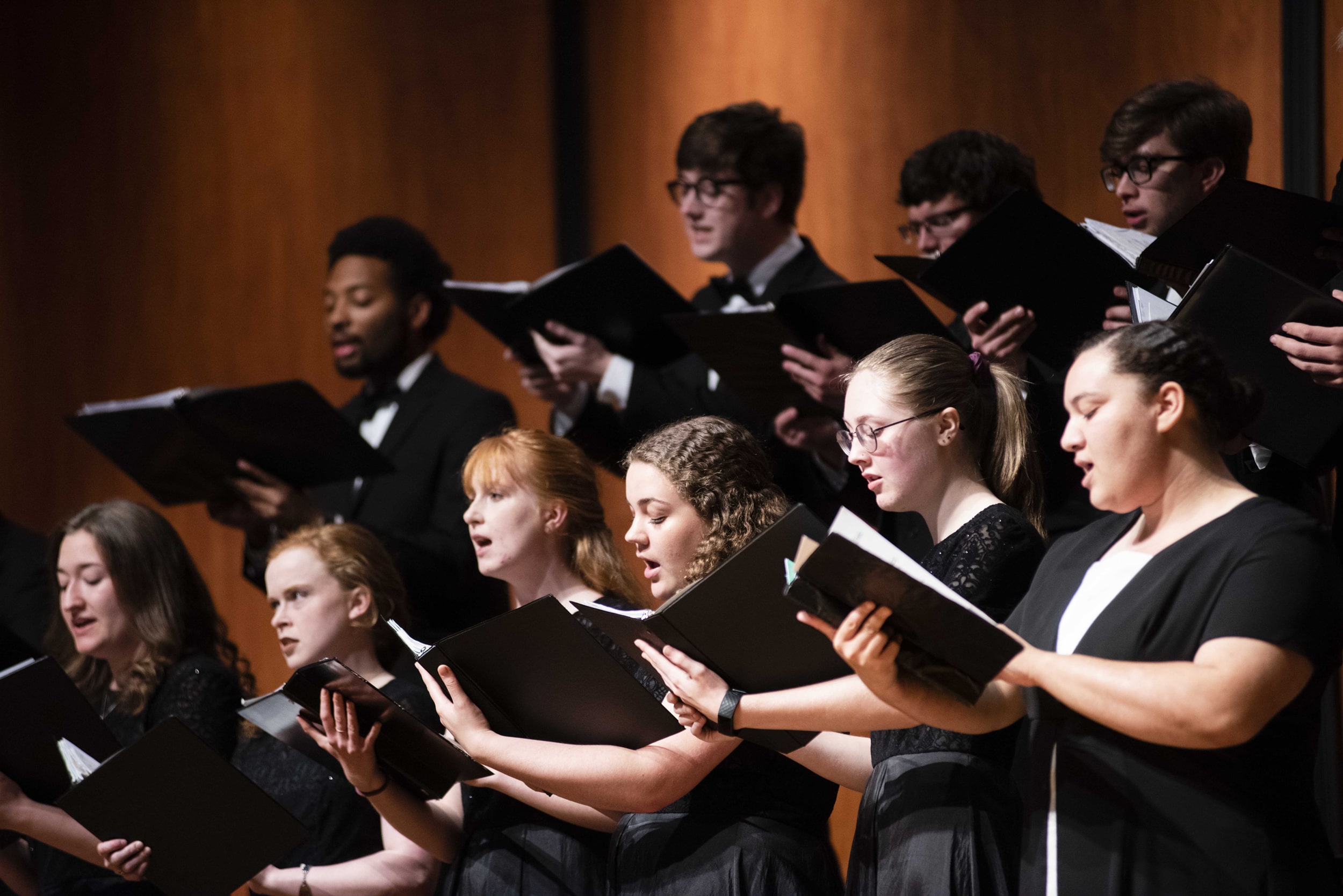 Group of diverse Georgia Southern students dressed in formal clothes singing in a choral performance.