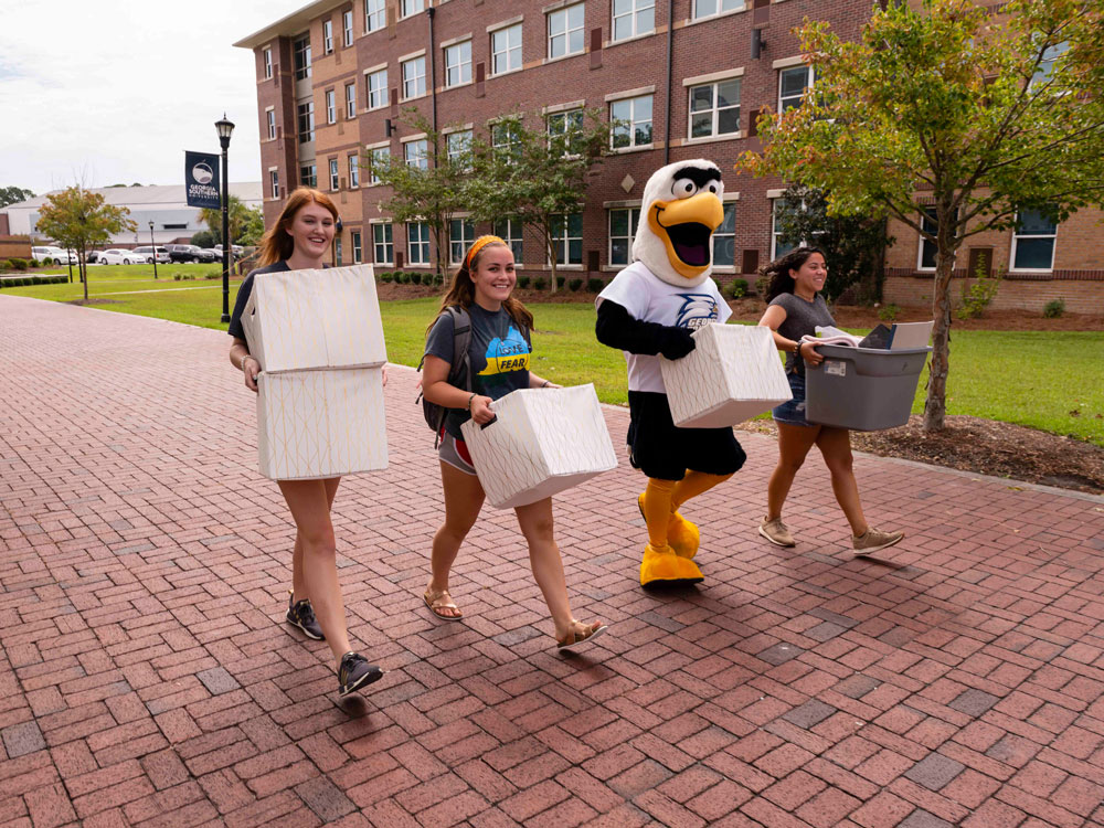 Three students plus the Georgia Southern mascot help out on move-in day