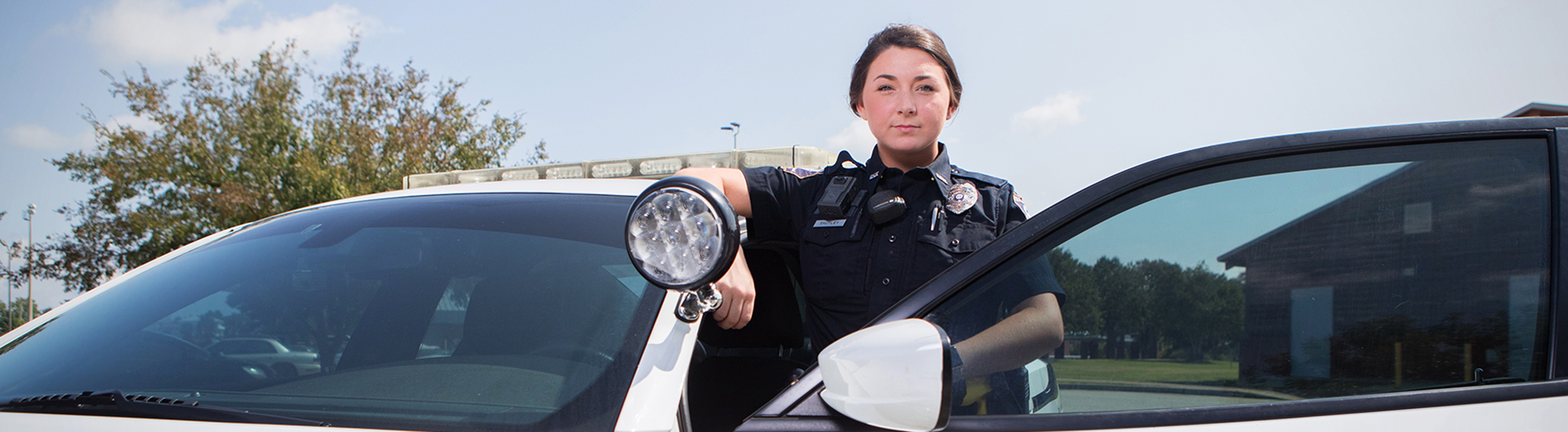 A Georgia Southern masters graduate in criminal justice poses in officer uniform.