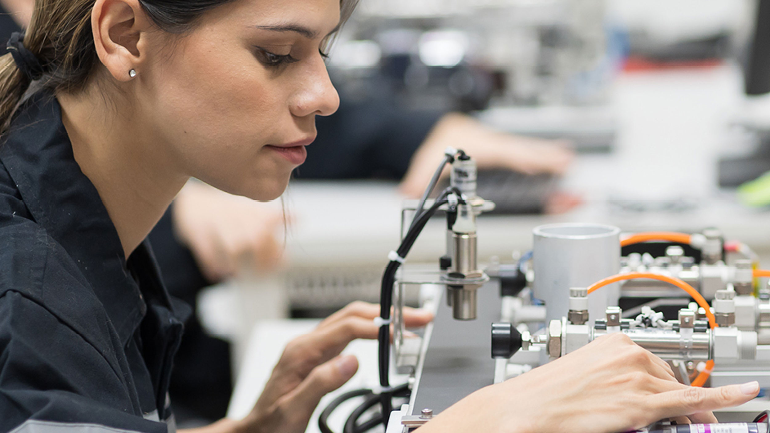 A student from Georgia Southern's M.S. in Electrical and Computer Engineering program studies and adjusts computer hardware