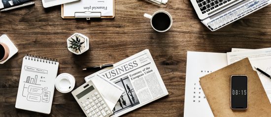Georgia Southern desk with business journal, notebooks, coffee, and calculator set up as a work station.