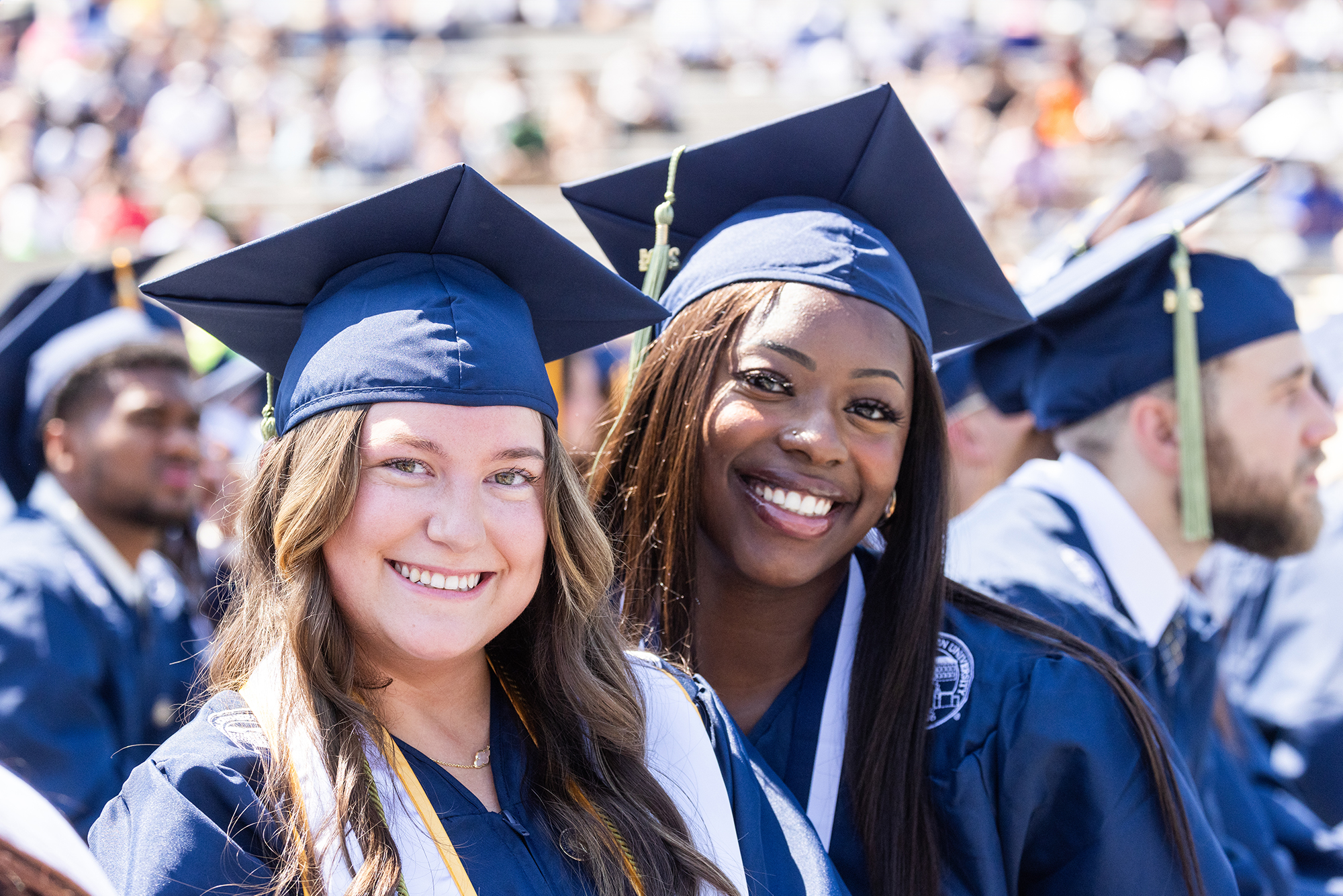 Two Georgia Southern adult learners smile at graduation after finishing their degrees.