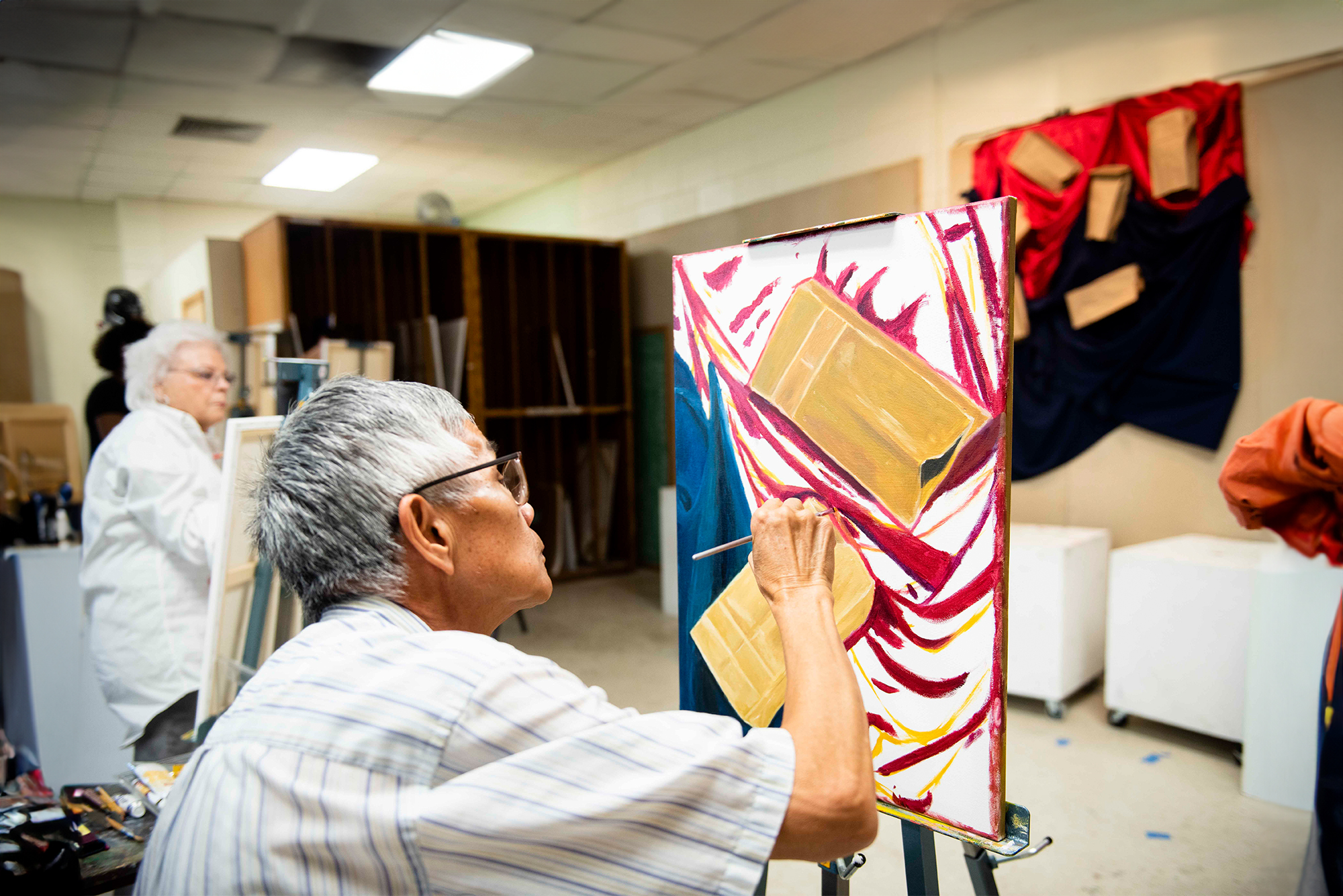 Georgia Southern continued education for adult art students shows older adults painting on canvas.