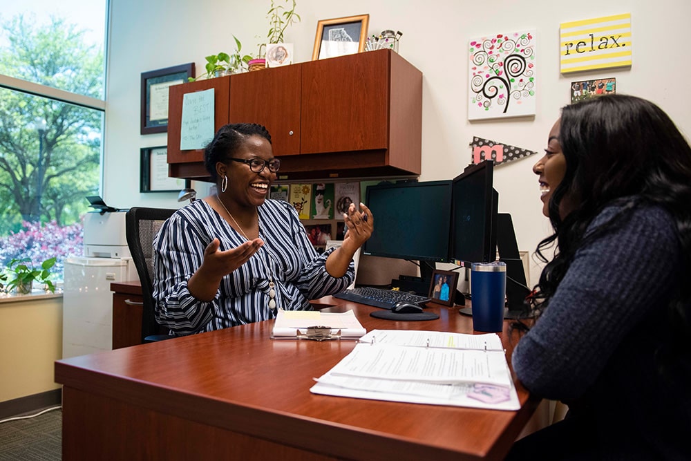A student has an animated conversation at the Academic Success Center.