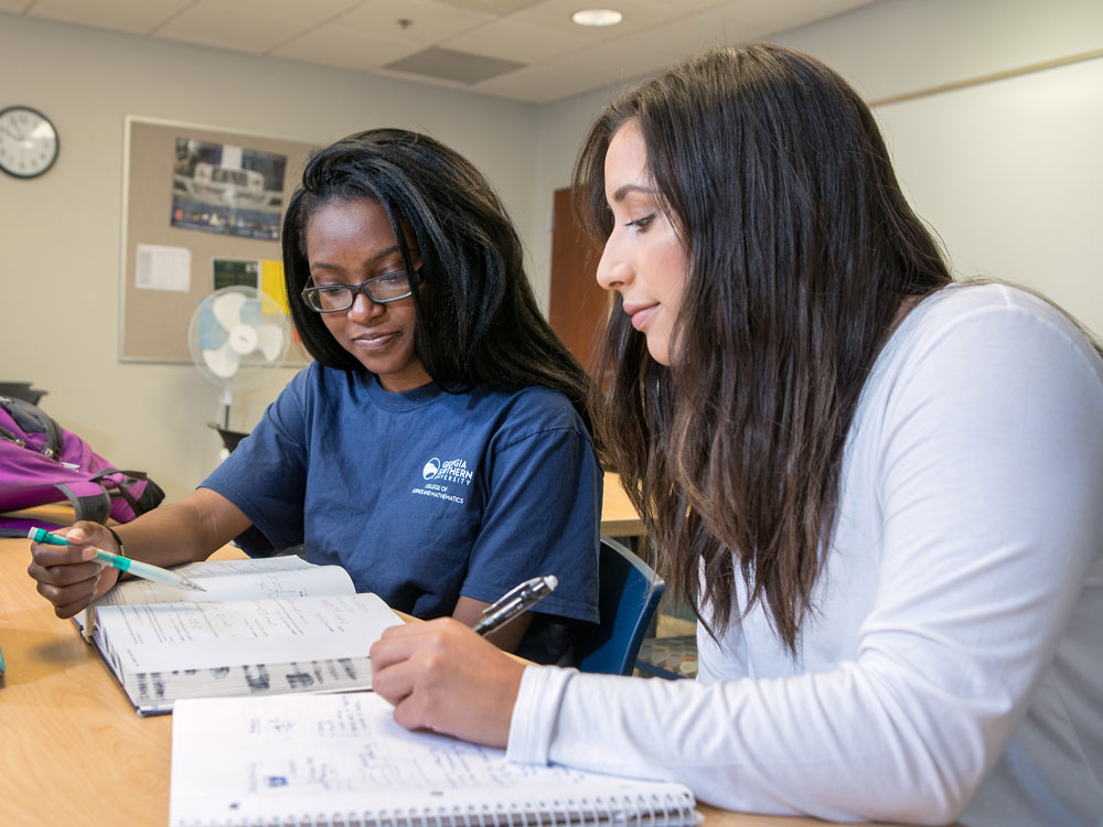 Two Georgia Southern Mathematics students study together to solve math equations.