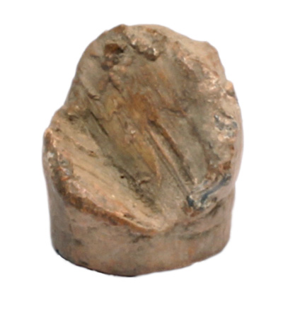 An irregular lumpy piece of brass, vaguely shaped like a bullet with a piece carved out.