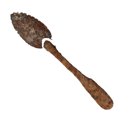 A very rusty spoon with the handle broken off.