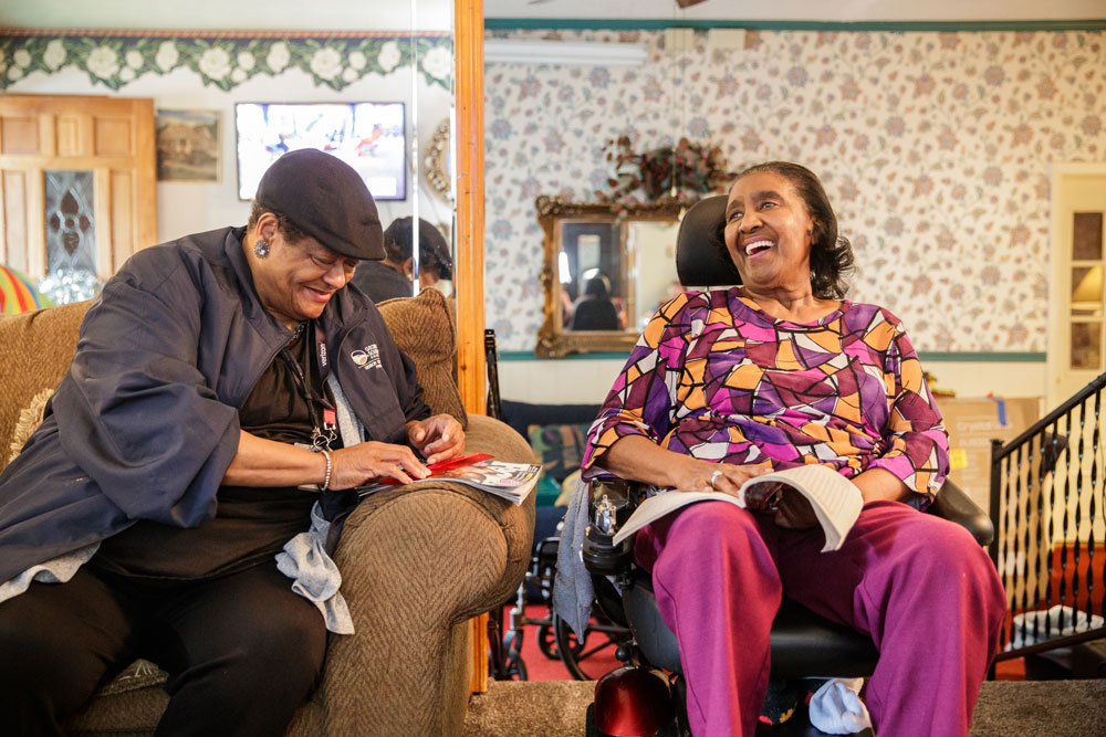An older lady speaking to a caretaker inside