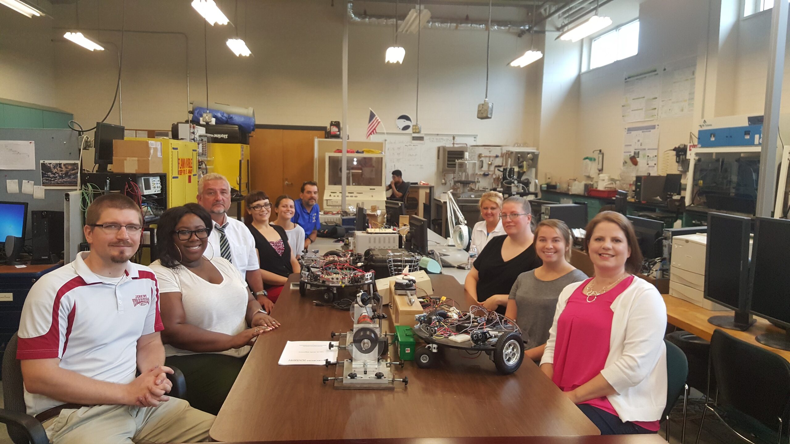 ENERGY participants posing for a picture with various technologies on the table