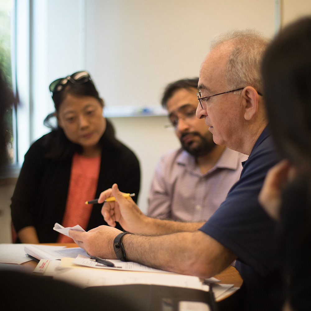 students and faculty siting around a table meeting