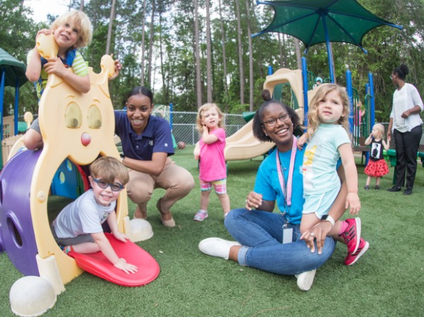 Georgia Southern students interact with young children on the playground.