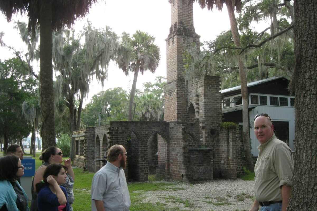 A field trip group explores ruins of a plantation house.