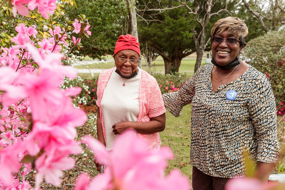 A middle-aged woman provides companionship to an elderly woman.