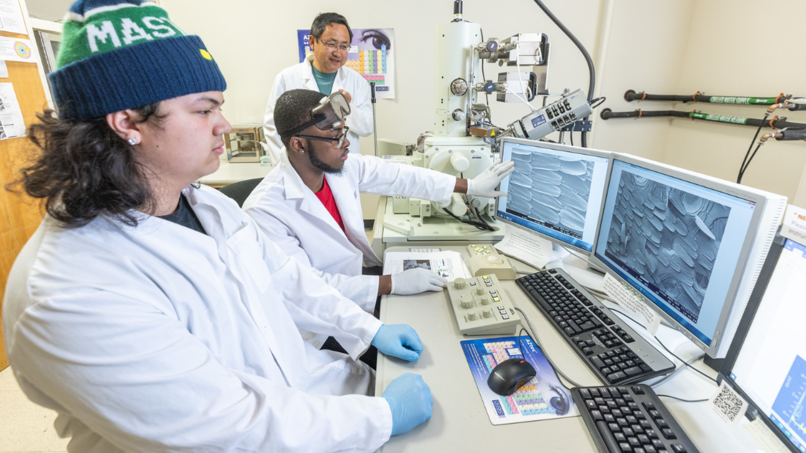 Student researchers work with microscopic imagery on computer screens.