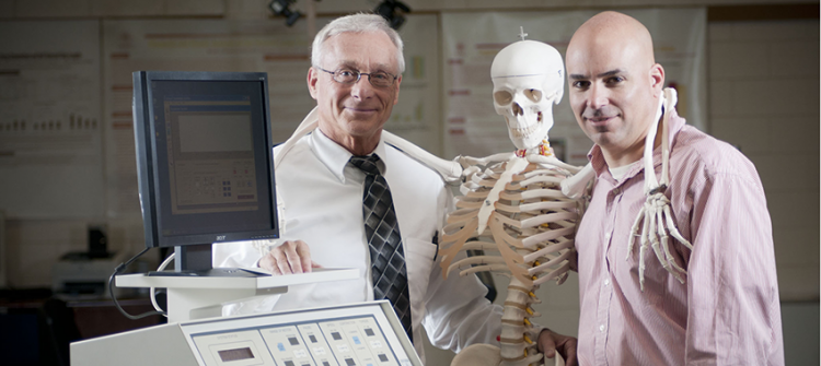 student and faculty posing with medical machines and a skeleton