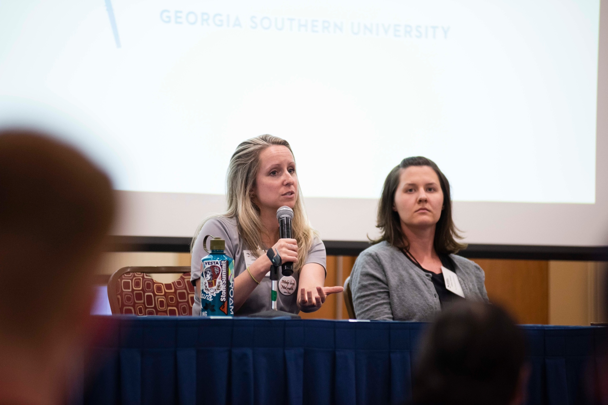 Two presenters speaking to a crowd of students