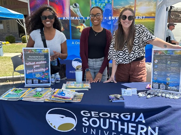 IHLA staffers man an information table at an event.