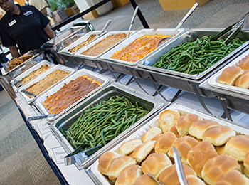 A table full of catered food prepared to be served at a large event.