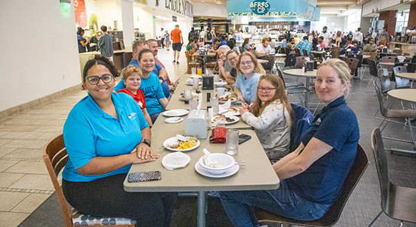 Staff and family members share a dining table in the Dining Commons.