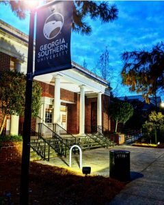The front of Jenkins Hall Theatre illuminated by nightlights in early evening.
