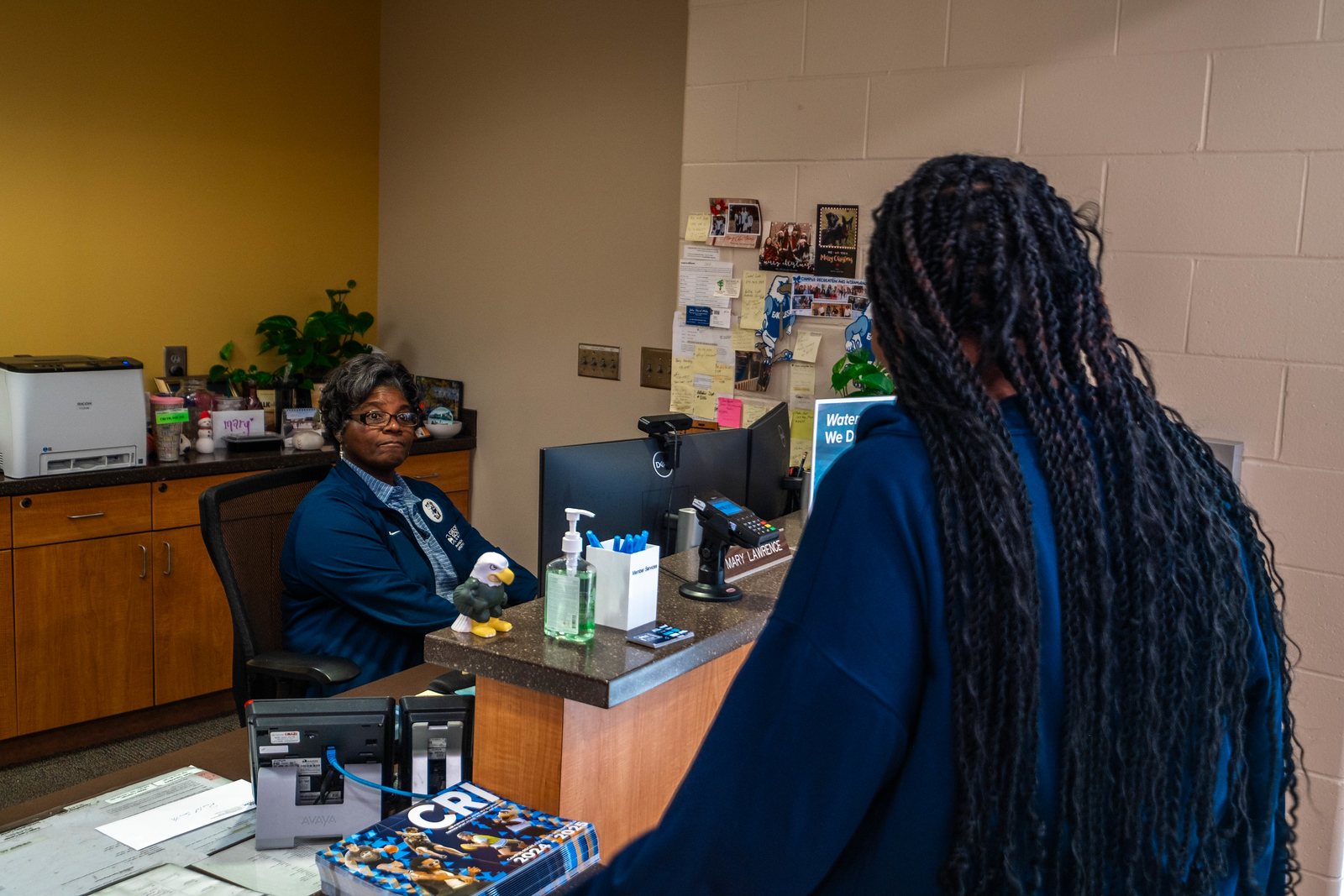 A Georgia Southern CRI Recreation center faculty checks a student in for intramural sport at the front desk.